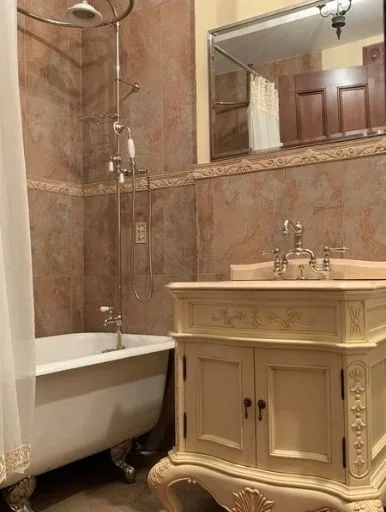 Bathroom after the remodel, with a clawfoot tub and cream vanity