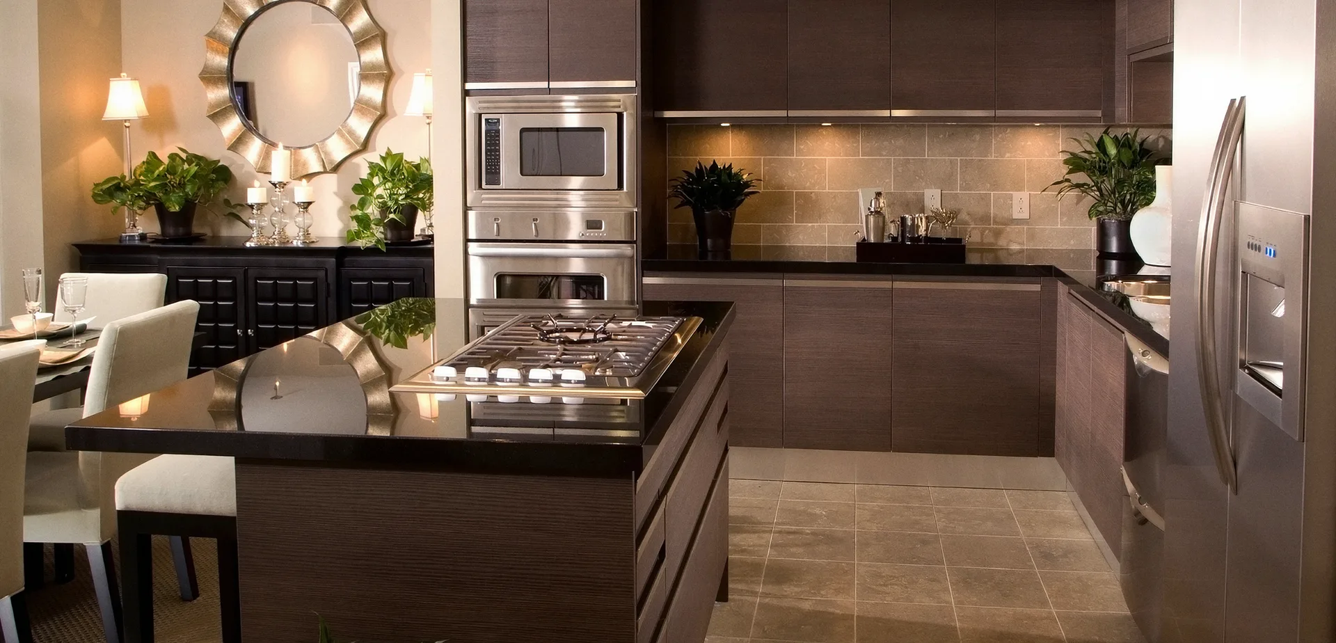 Kitchen with dark wood cabinets, a black stone island and stainless appliances
