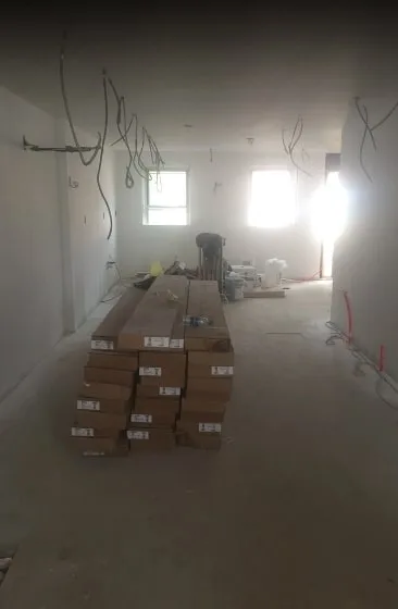 The room during construction, bare walls and boxed cabinets