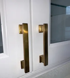 Brass cabinet pulls on white doors
